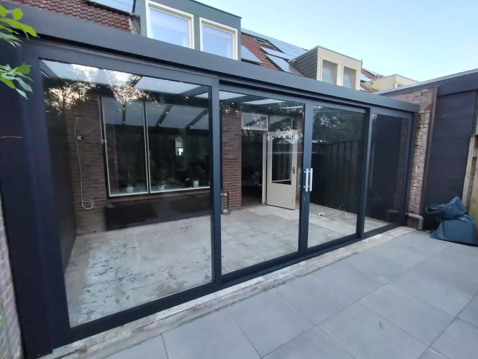 Luxe veranda met glazen schuifwanden en strakke afwerking Veratuin Nederland